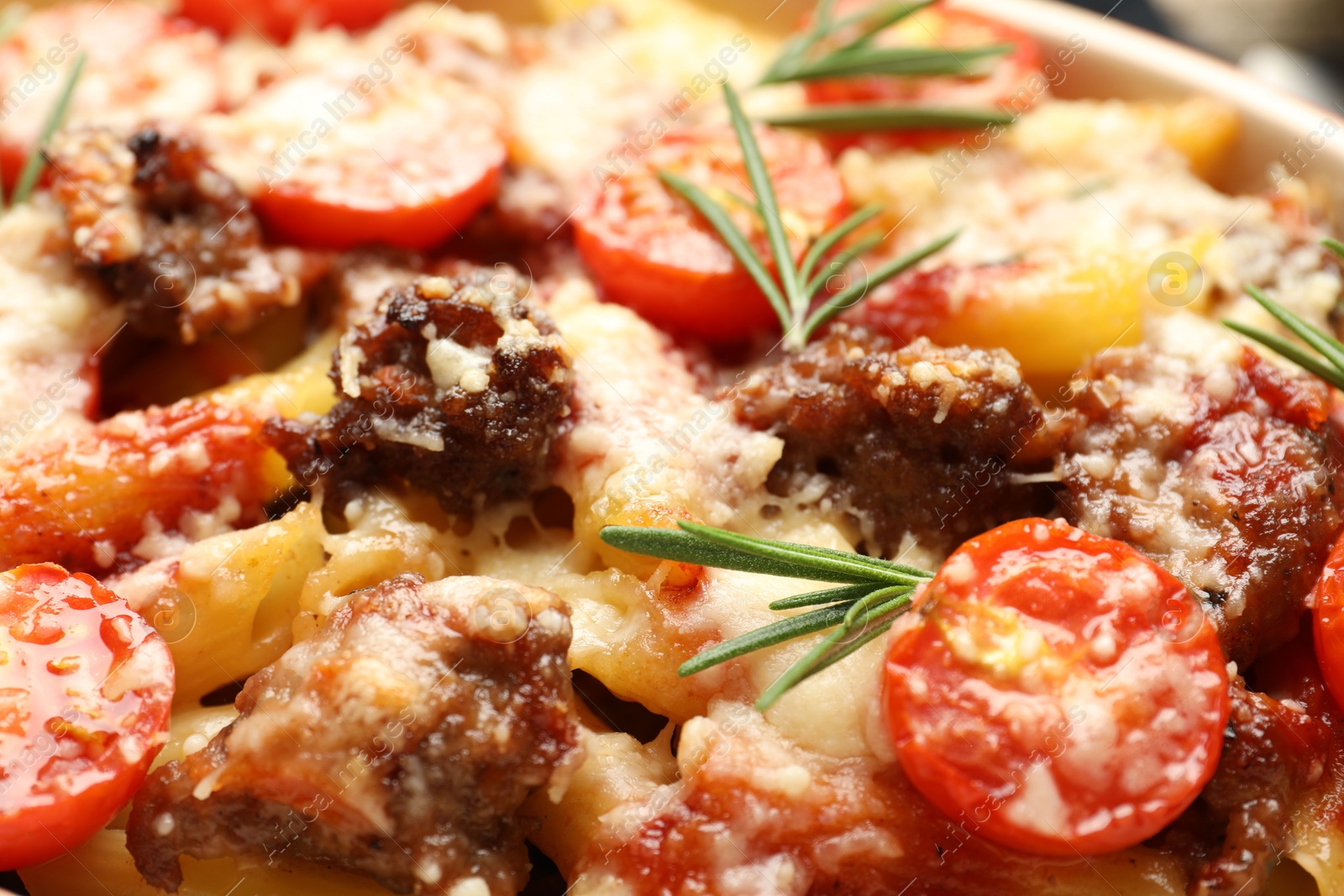 Photo of Delicious pasta casserole with cheese, tomatoes, minced meat and rosemary, closeup