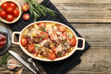 Photo of Flat lay composition with delicious pasta casserole in baking dish and ingredients on wooden table