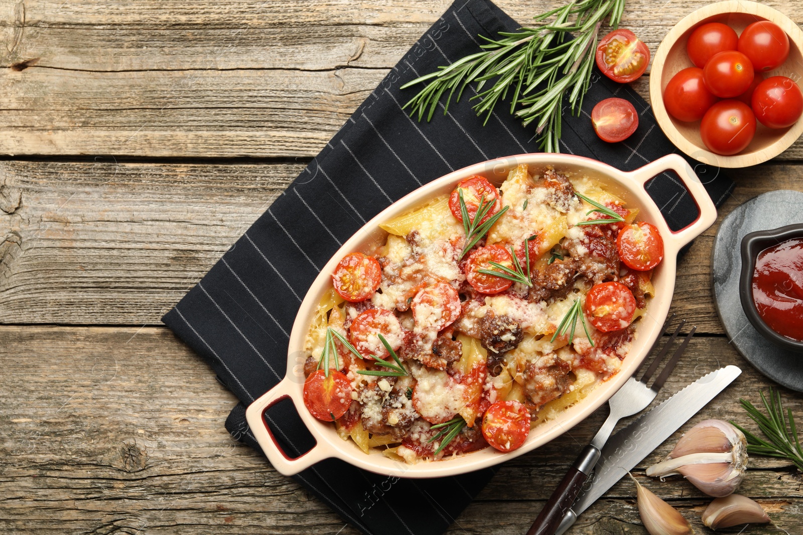 Photo of Flat lay composition with delicious pasta casserole in baking dish and ingredients on wooden table