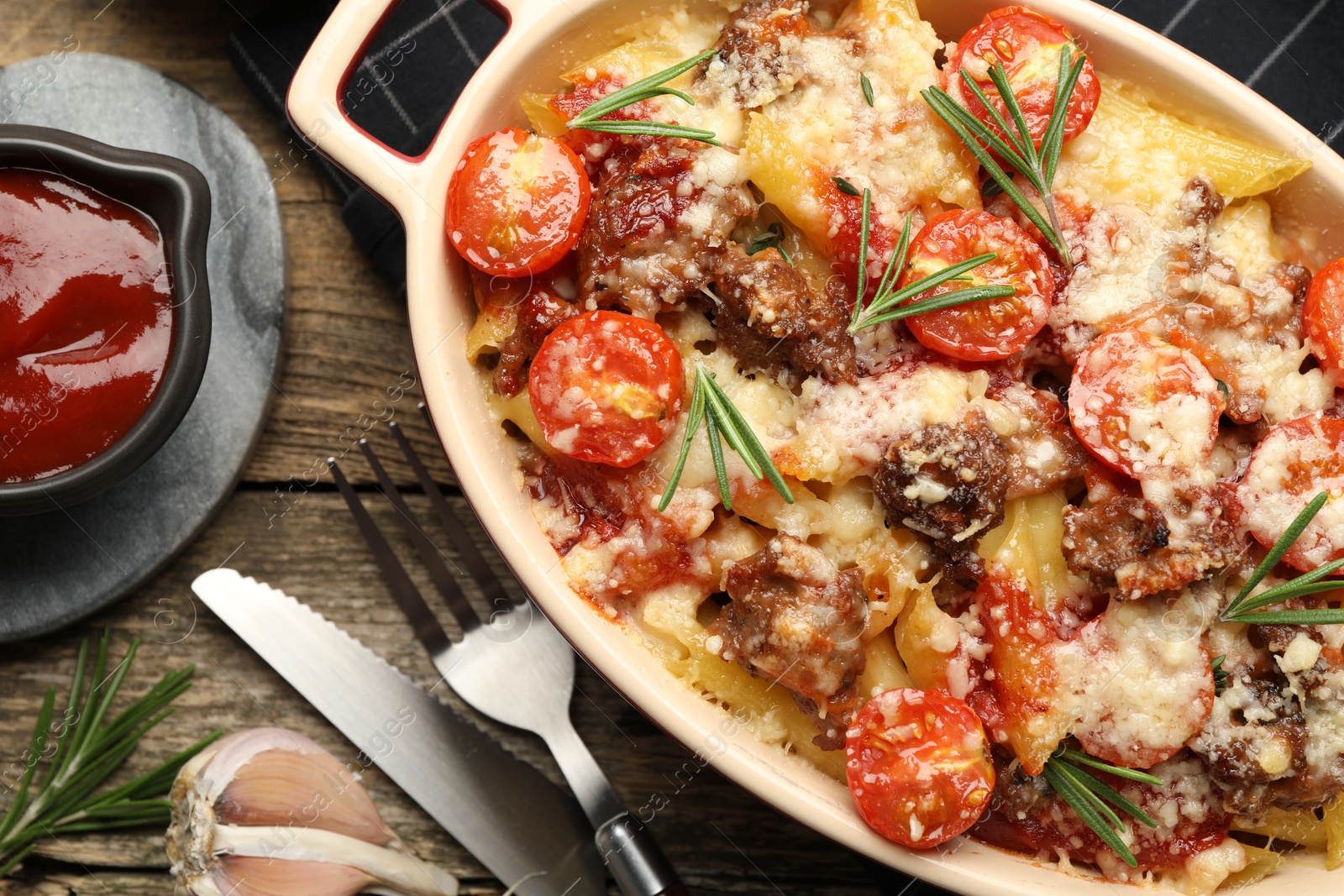 Photo of Flat lay composition with delicious pasta casserole in baking dish and ingredients on wooden table