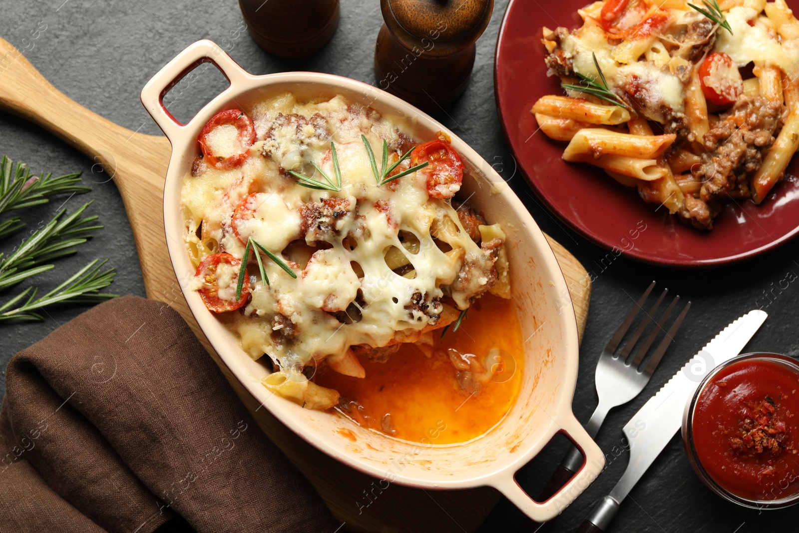 Photo of Flat lay composition with delicious pasta casserole on dark textured table