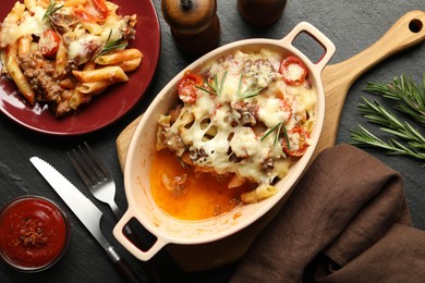 Photo of Flat lay composition with delicious pasta casserole on dark textured table