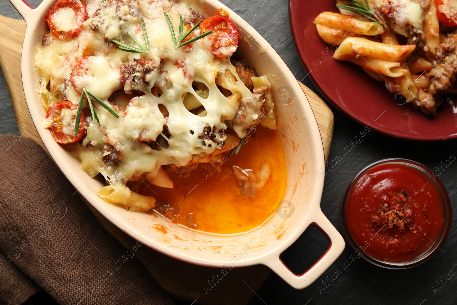 Photo of Flat lay composition with delicious pasta casserole on dark textured table