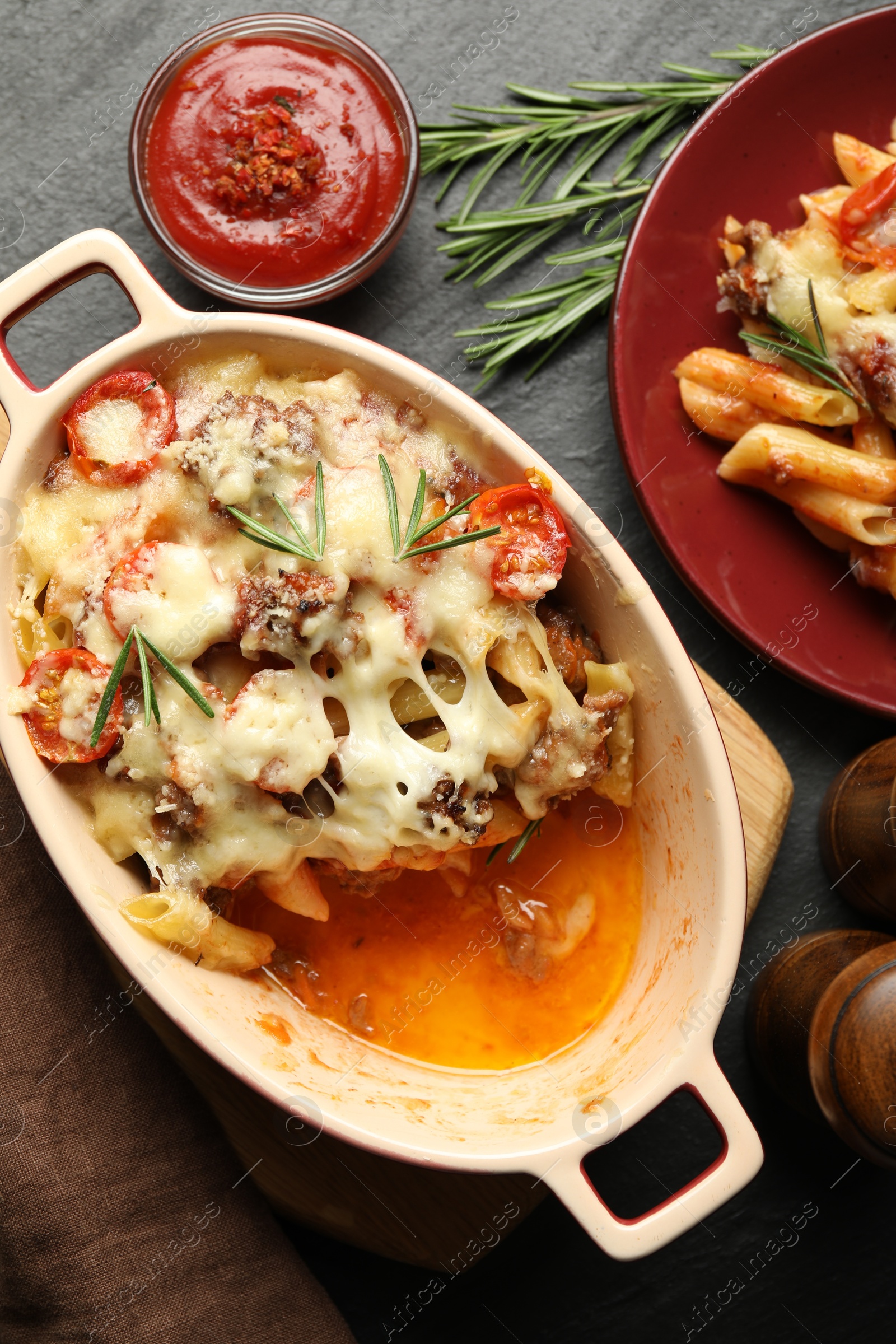 Photo of Flat lay composition with delicious pasta casserole on dark textured table