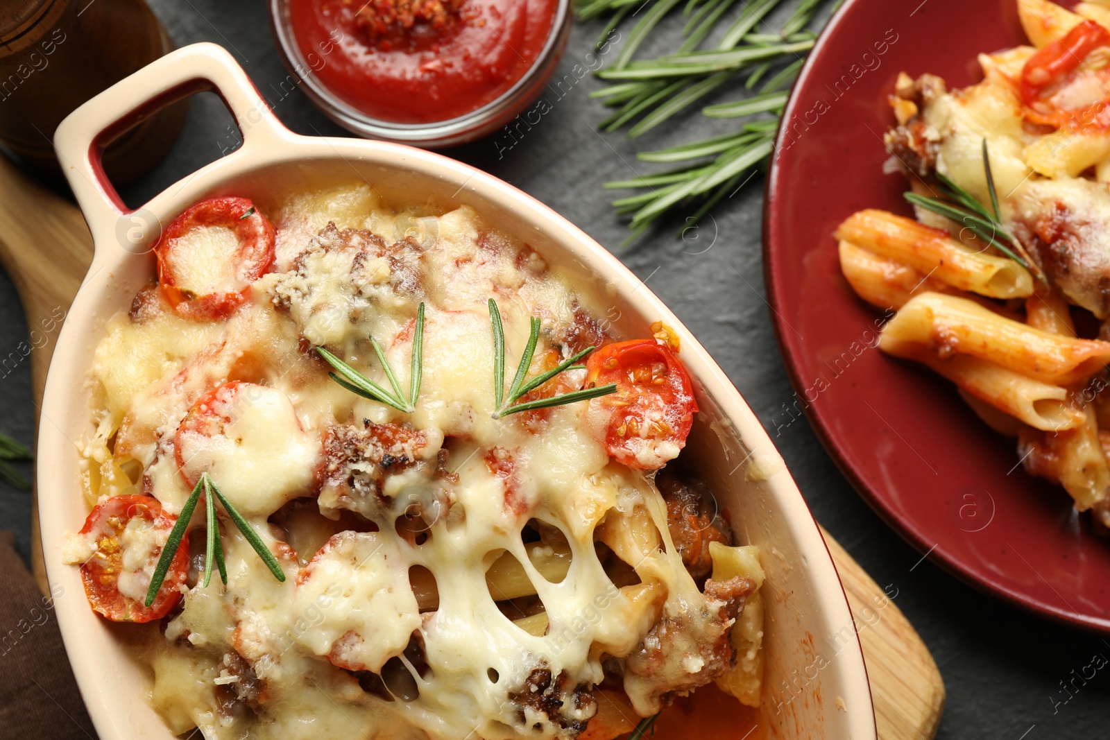 Photo of Flat lay composition with delicious pasta casserole on dark table