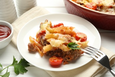 Photo of Delicious pasta casserole with cheese, tomatoes, minced meat and parsley on white wooden table, closeup