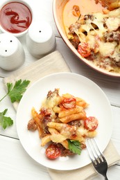 Photo of Flat lay composition with delicious pasta casserole served on white wooden table