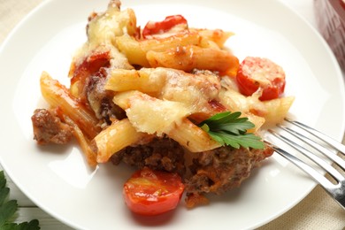 Photo of Delicious pasta casserole with cheese, tomatoes, minced meat and parsley on table, closeup