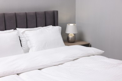 Photo of Bed with clean linens and pillows indoors