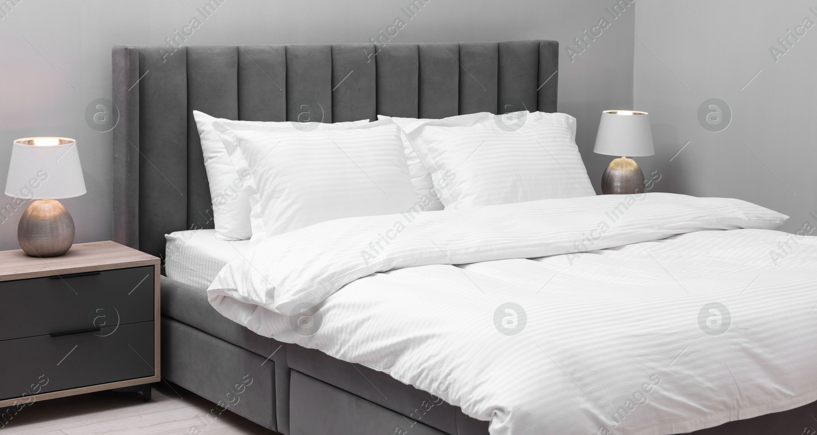 Photo of Bed with clean linens and pillows indoors