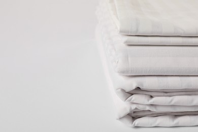 Photo of Stacked clean bed linens on white background