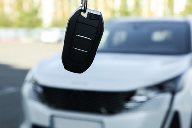 Photo of Woman holding key near car outdoors, closeup