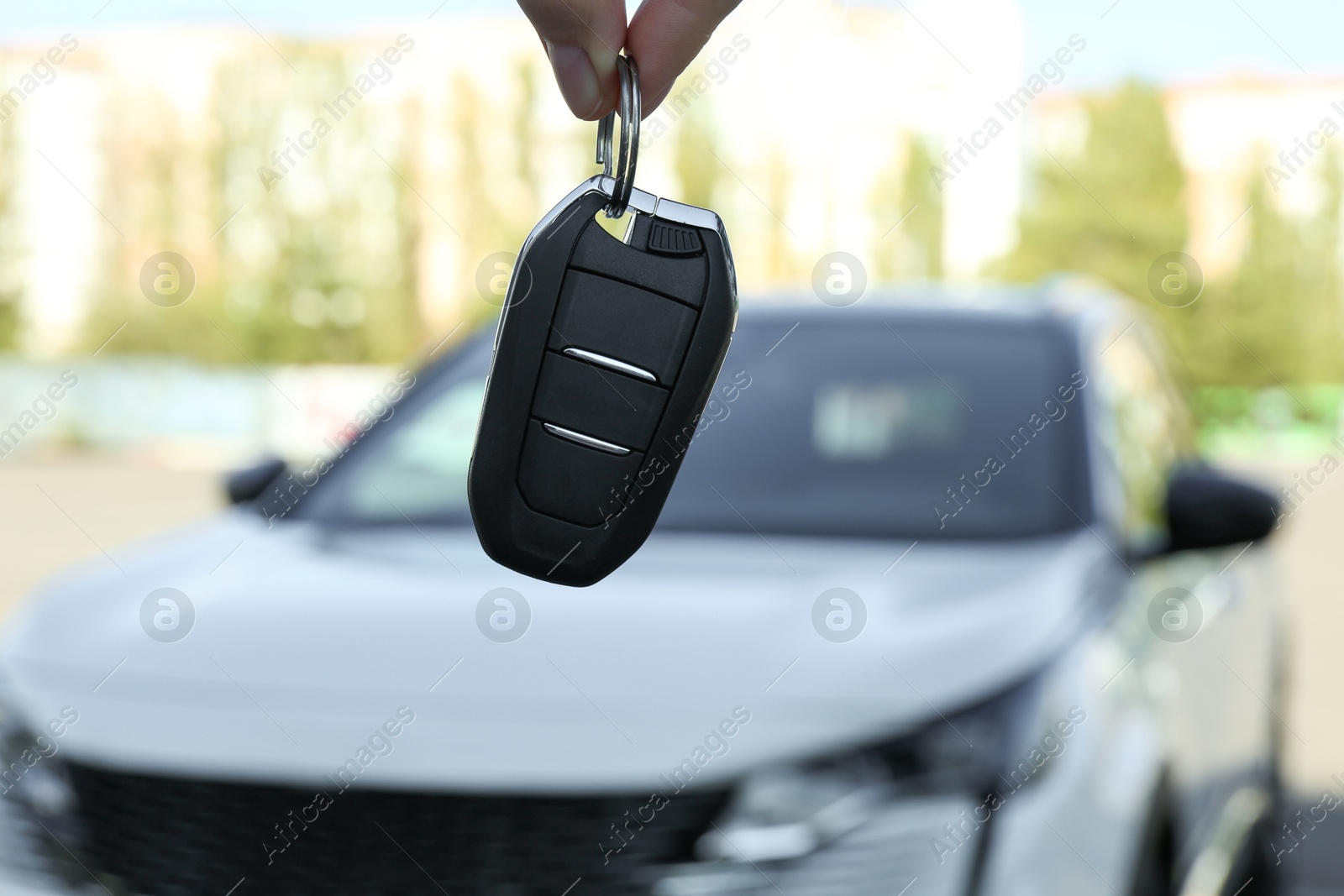 Photo of Woman holding key near car outdoors, closeup