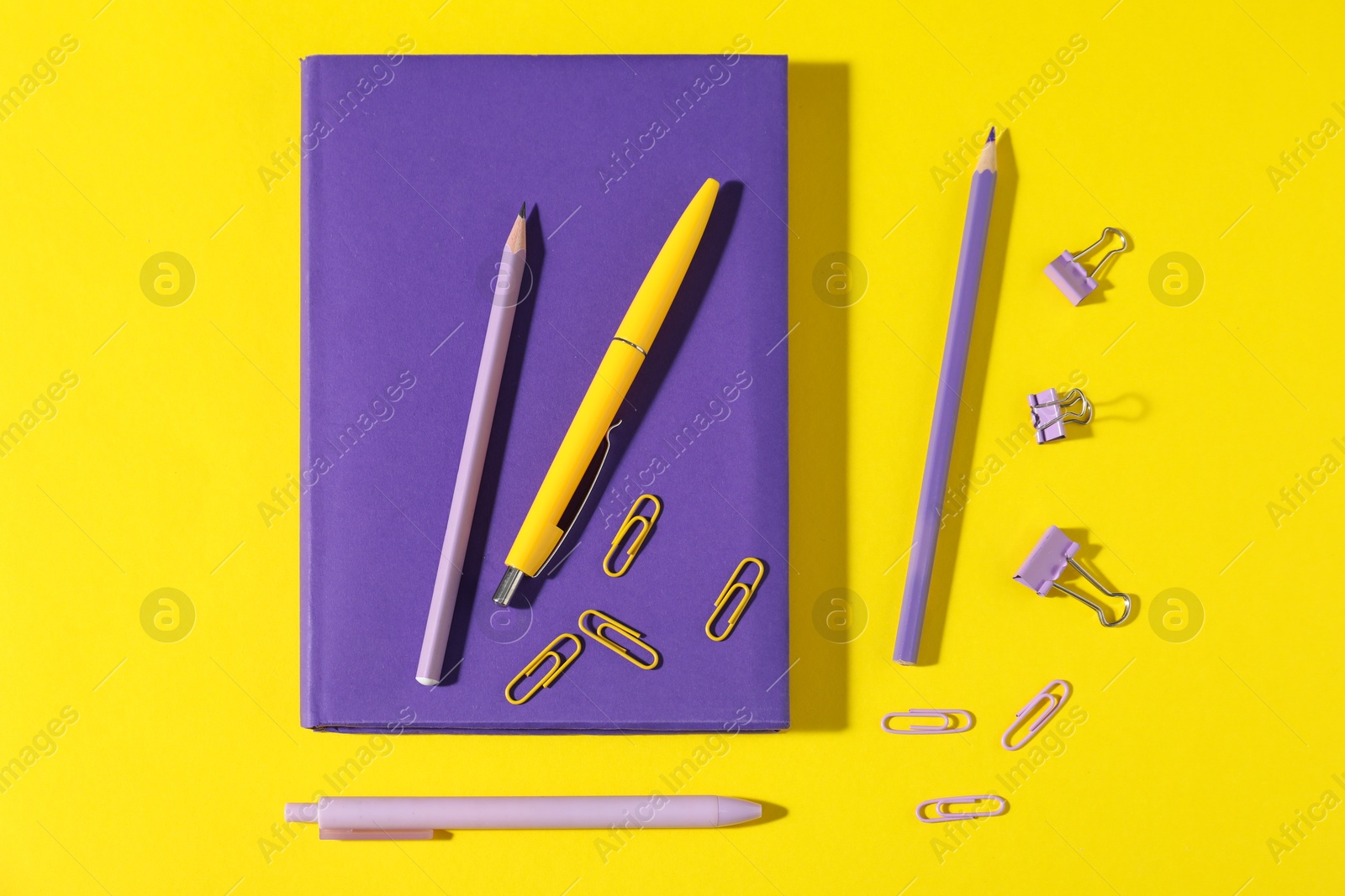 Photo of Different bright stationery on yellow background, flat lay