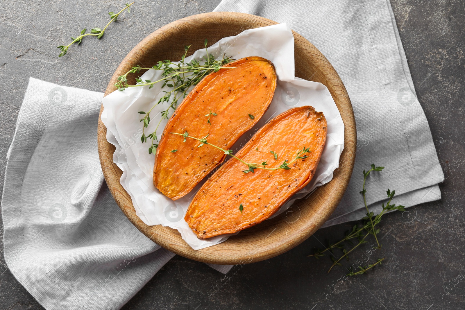 Photo of Tasty cooked sweet potato with thyme on grey table, top view