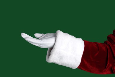 Photo of Santa Claus holding something on green background, closeup