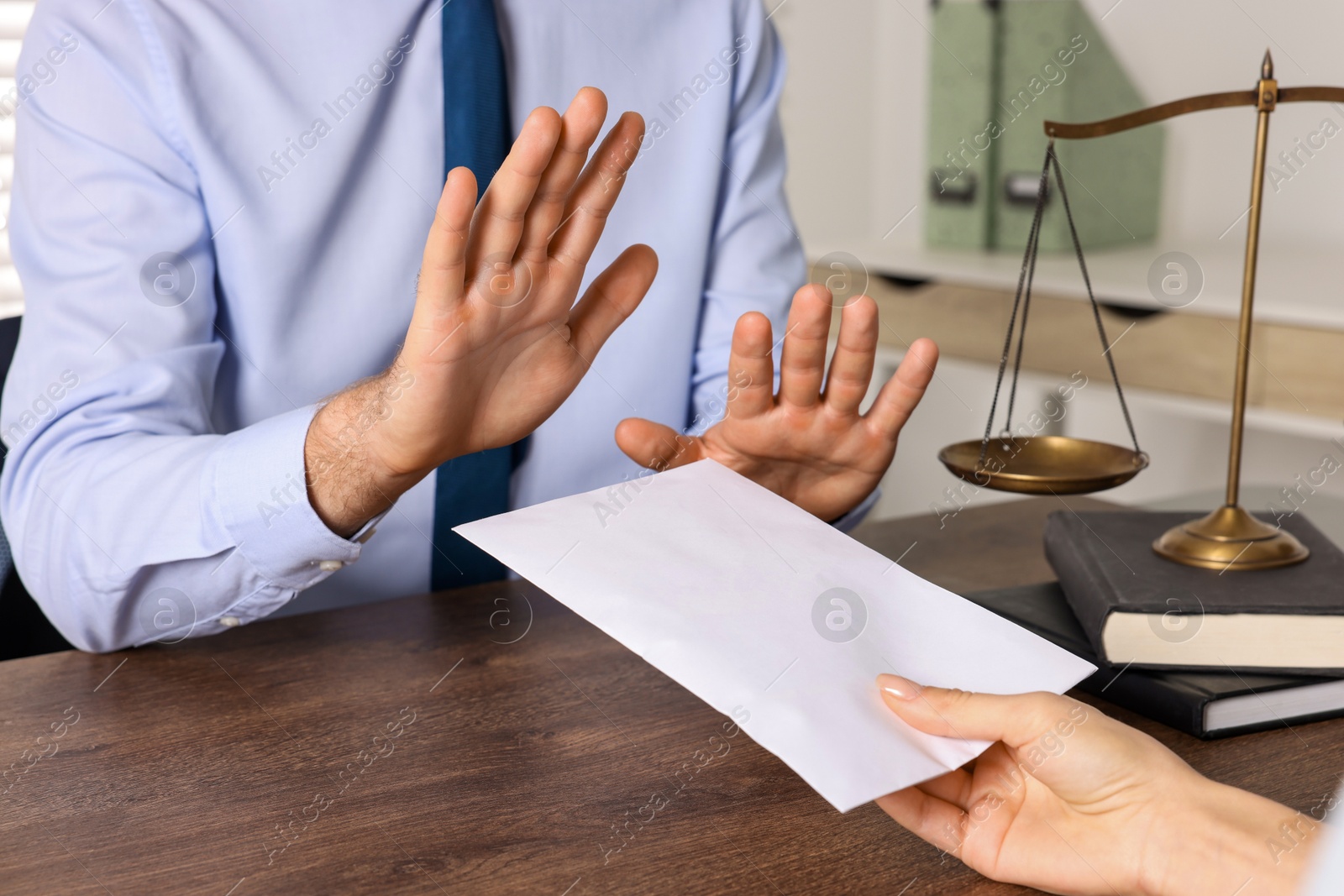 Photo of Corruption concept. Woman giving envelope with money to man at wooden table, closeup