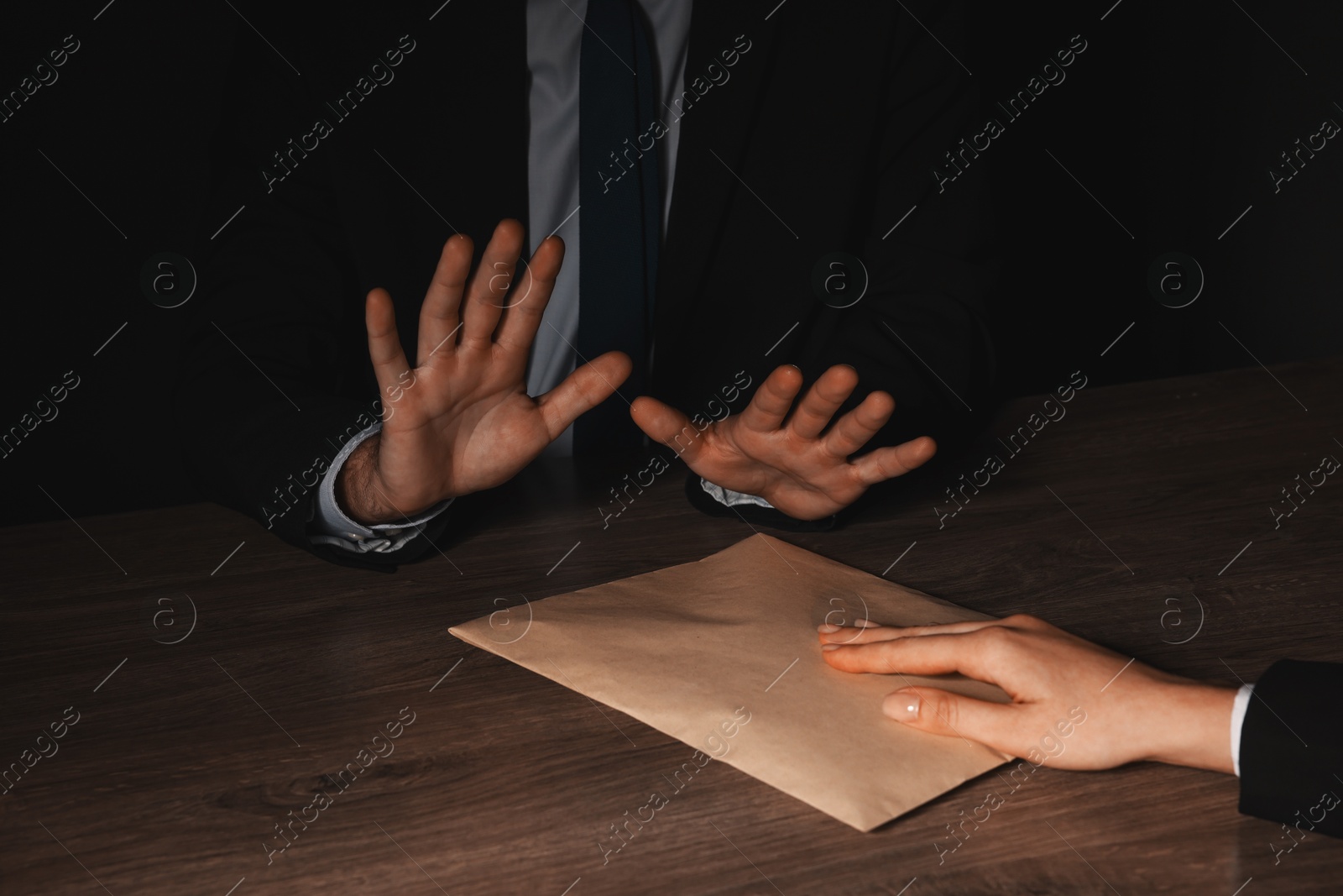 Photo of Corruption concept. Woman giving envelope with money to man at wooden table, closeup