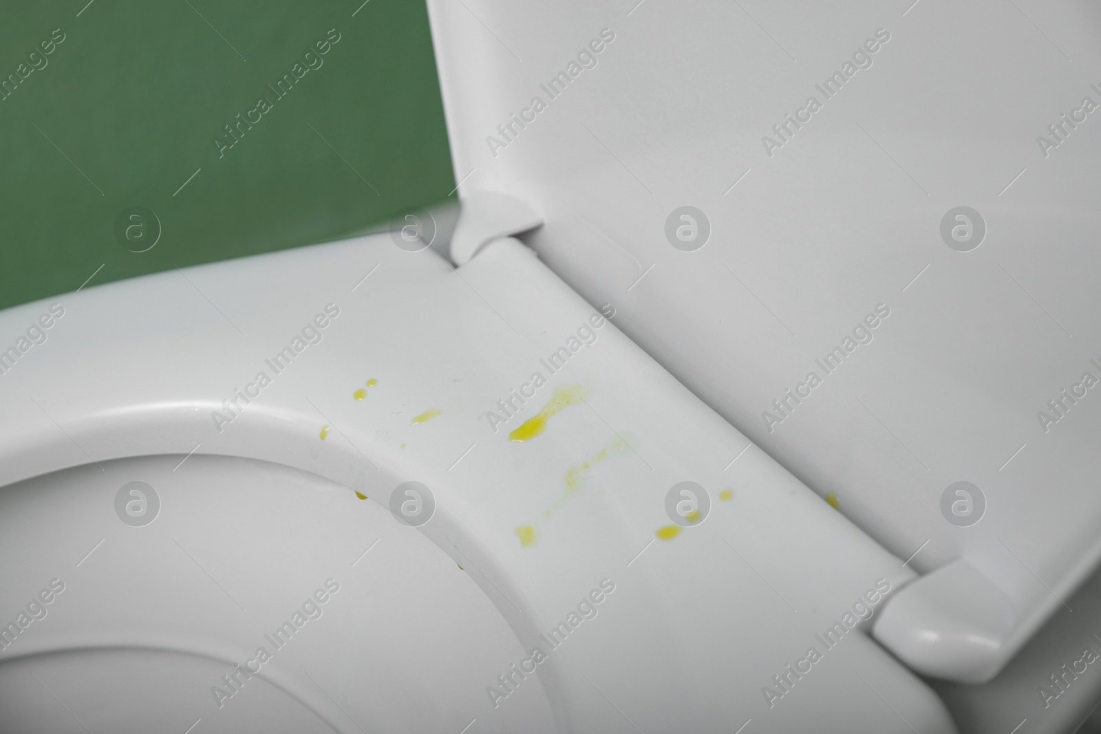 Photo of Urine drops on toilet seat in restroom, closeup