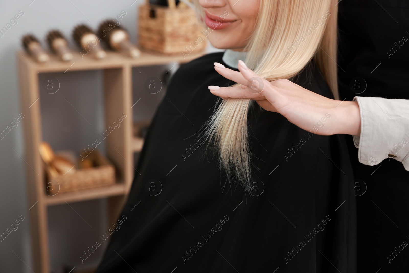 Photo of Hair cutting. Professional hairdresser working with client in salon, closeup