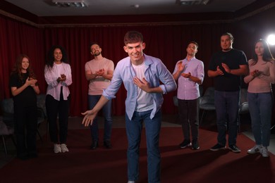 Photo of Professional actors bowing on stage in theatre