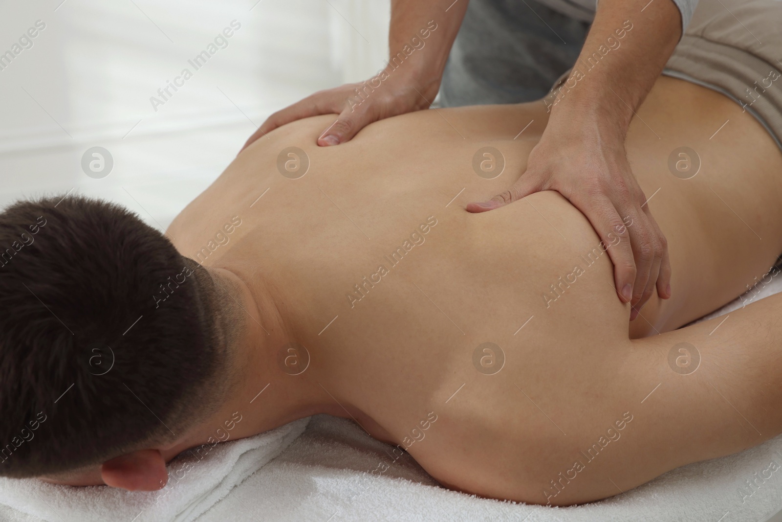 Photo of Massage therapist working with patient in clinic, closeup