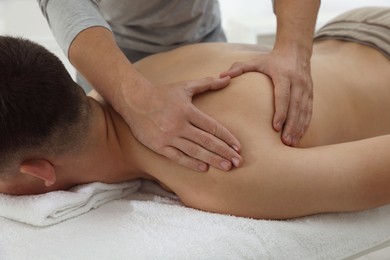 Photo of Massage therapist working with patient in clinic, closeup