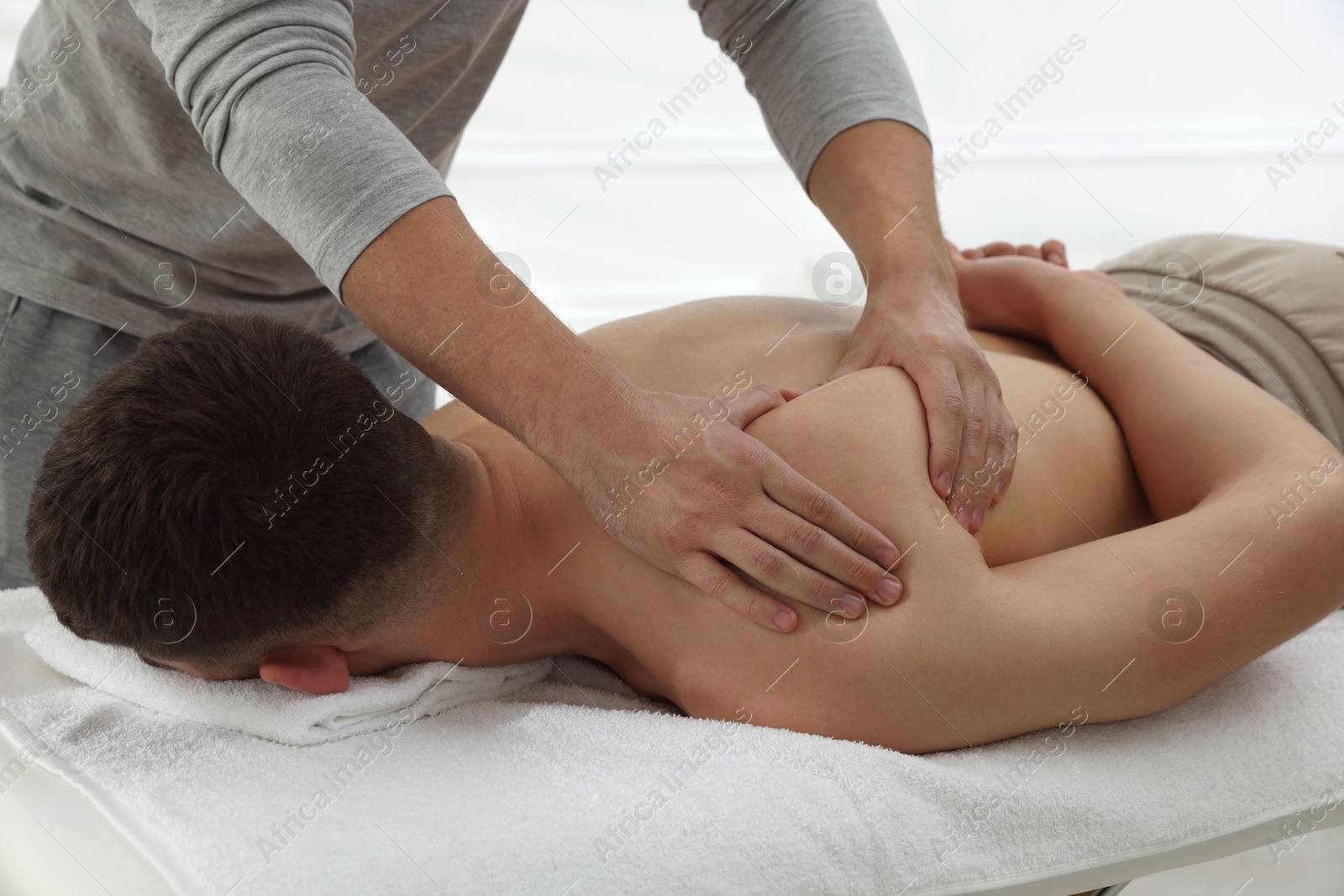 Photo of Massage therapist working with patient in clinic, closeup