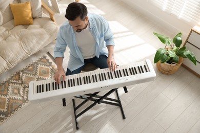 Photo of Man playing synthesizer at home, above view