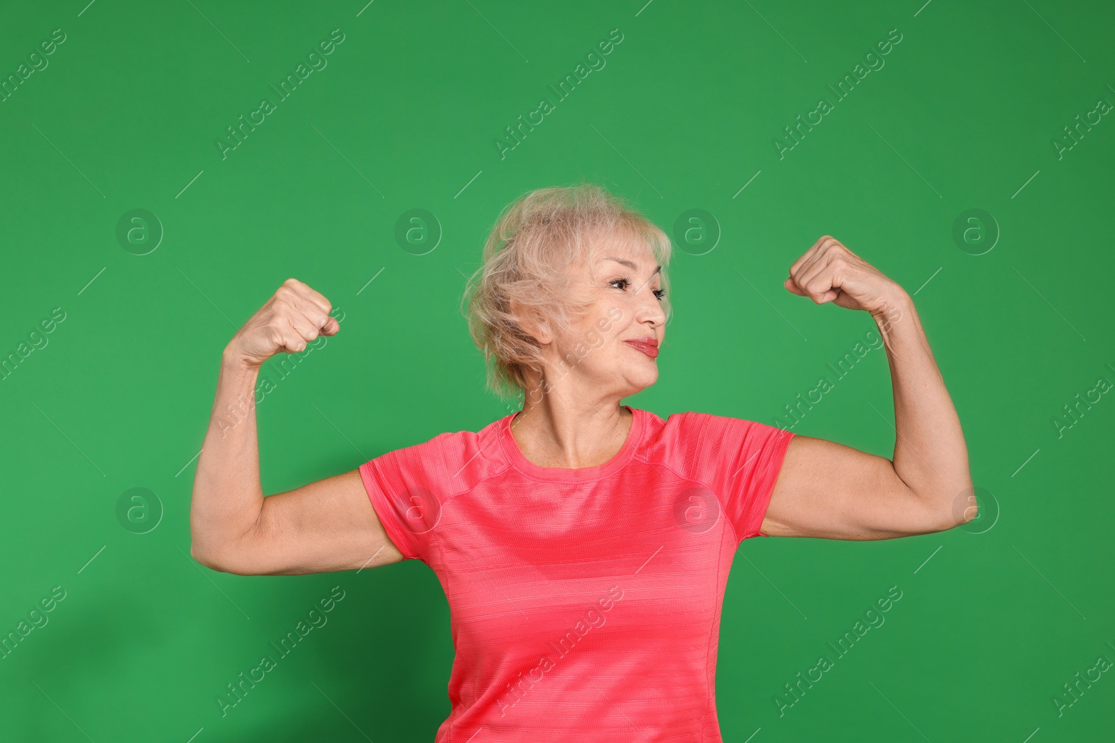 Photo of Senior woman exercising on green background. Healthy lifestyle