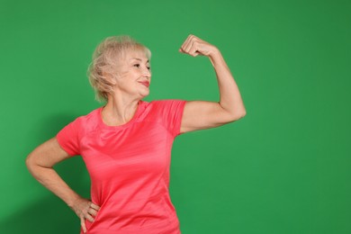 Photo of Senior woman exercising on green background, space for text