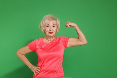 Photo of Senior woman exercising on green background. Healthy lifestyle