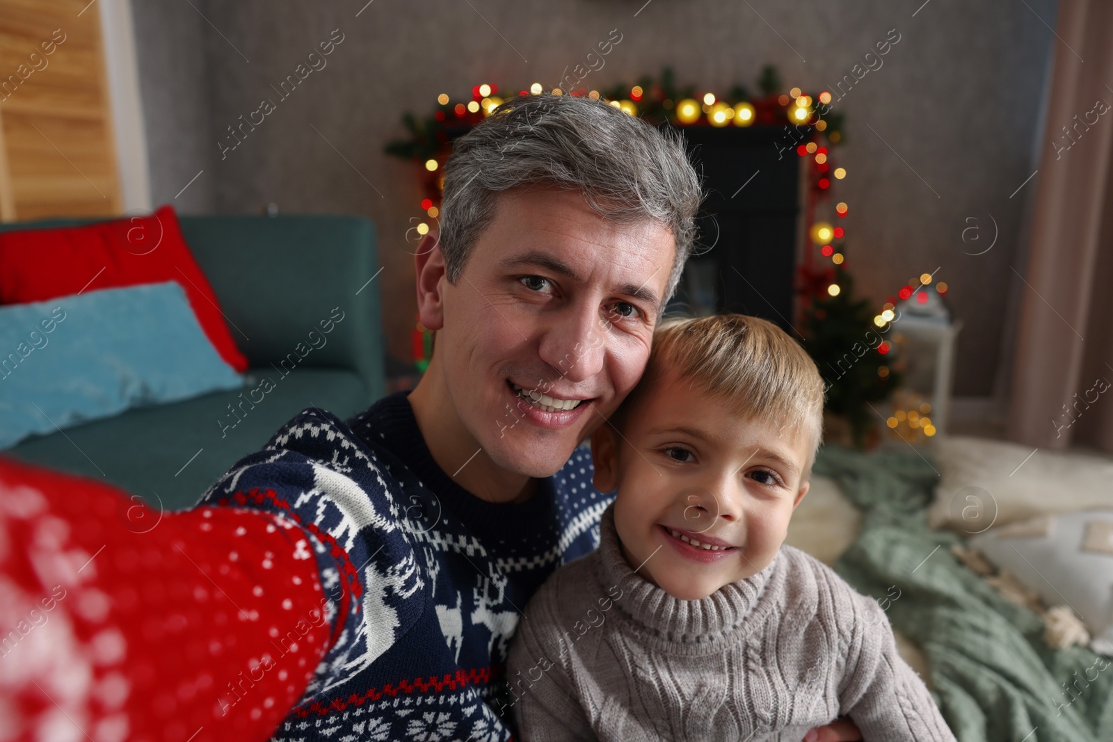 Photo of Dad and son taking selfie together at home. Christmas season