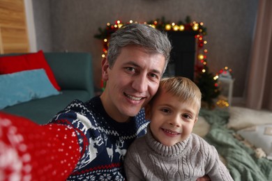 Photo of Dad and son taking selfie together at home. Christmas season