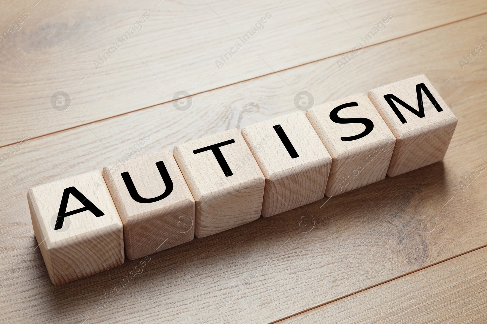 Photo of Word Autism made of cubes on wooden background