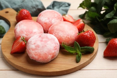 Photo of Delicious mochi, strawberries and mint on wooden table, closeup