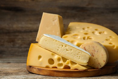 Photo of Different types of cheese on wooden table, closeup