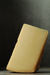 Photo of Piece of tasty cheese on grey table