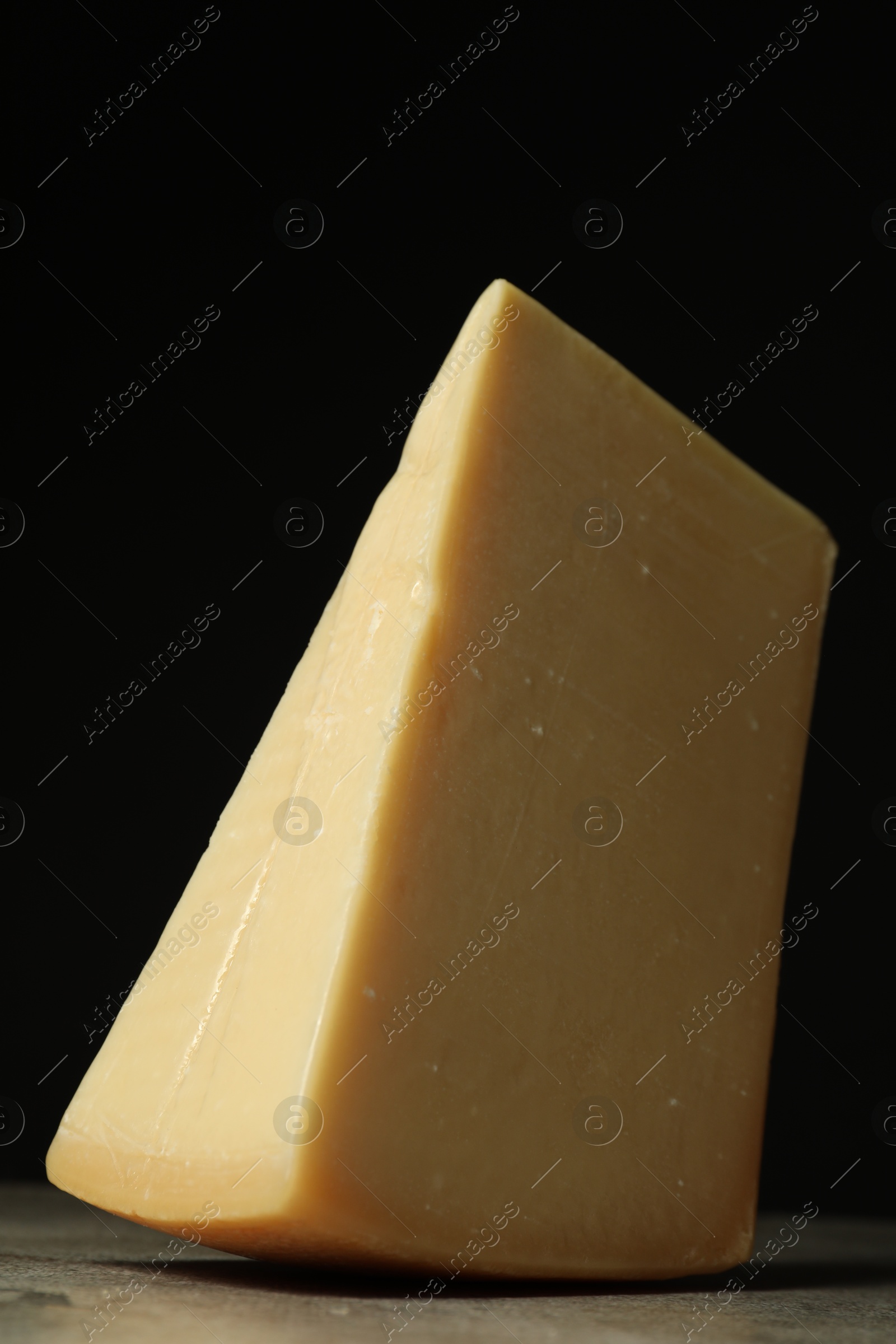 Photo of Piece of tasty cheese on grey table, closeup