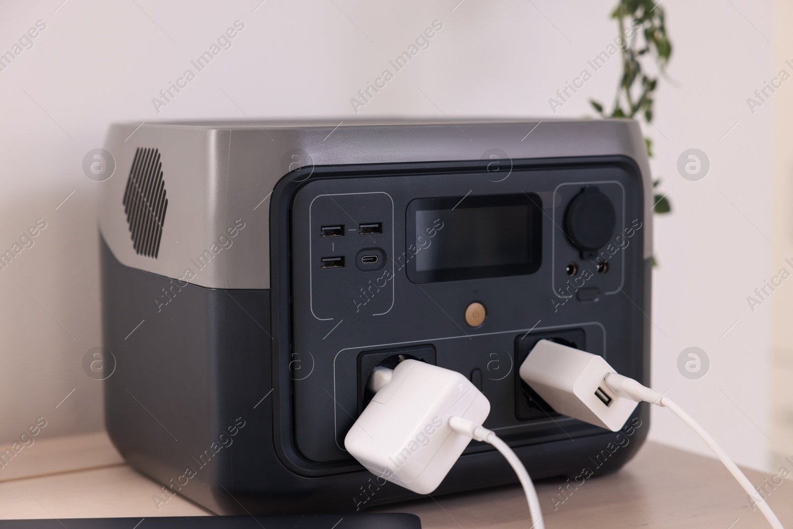 Photo of Portable power station with chargers on table indoors