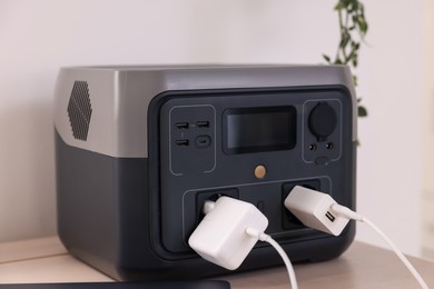 Photo of Portable power station with chargers on table indoors