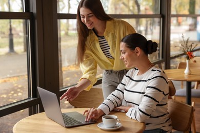 Photo of Women with laptop working together in cafe