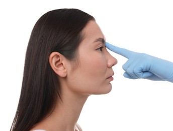 Photo of Doctor checking patient's nose before plastic surgery operation on white background, closeup