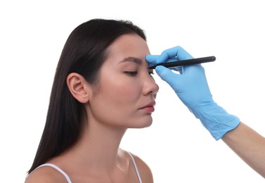 Photo of Doctor drawing marks on patient's nose for plastic surgery operation against white background, closeup