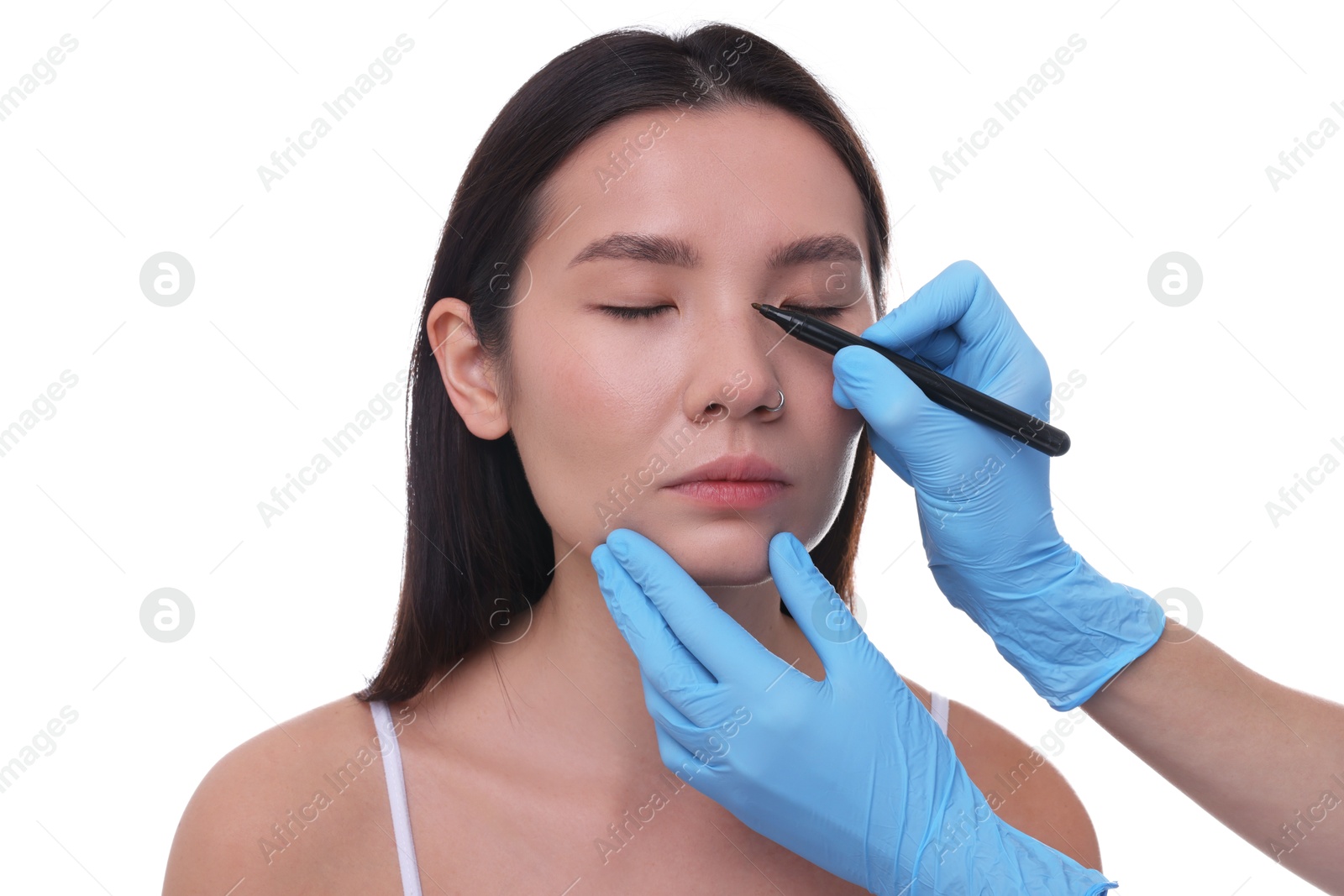 Photo of Doctor drawing marks on patient's nose for plastic surgery operation against white background, closeup