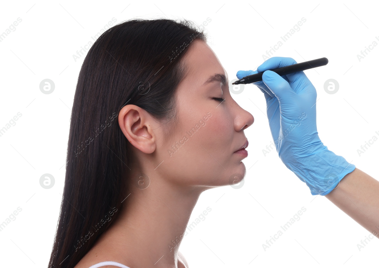 Photo of Doctor drawing marks on patient's nose for plastic surgery operation against white background, closeup