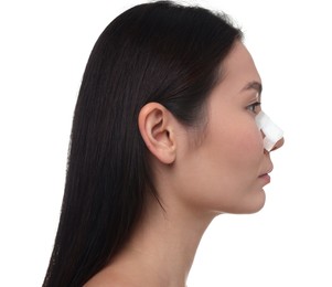 Photo of Woman with medical bandage on her nose after plastic surgery operation against white background, closeup