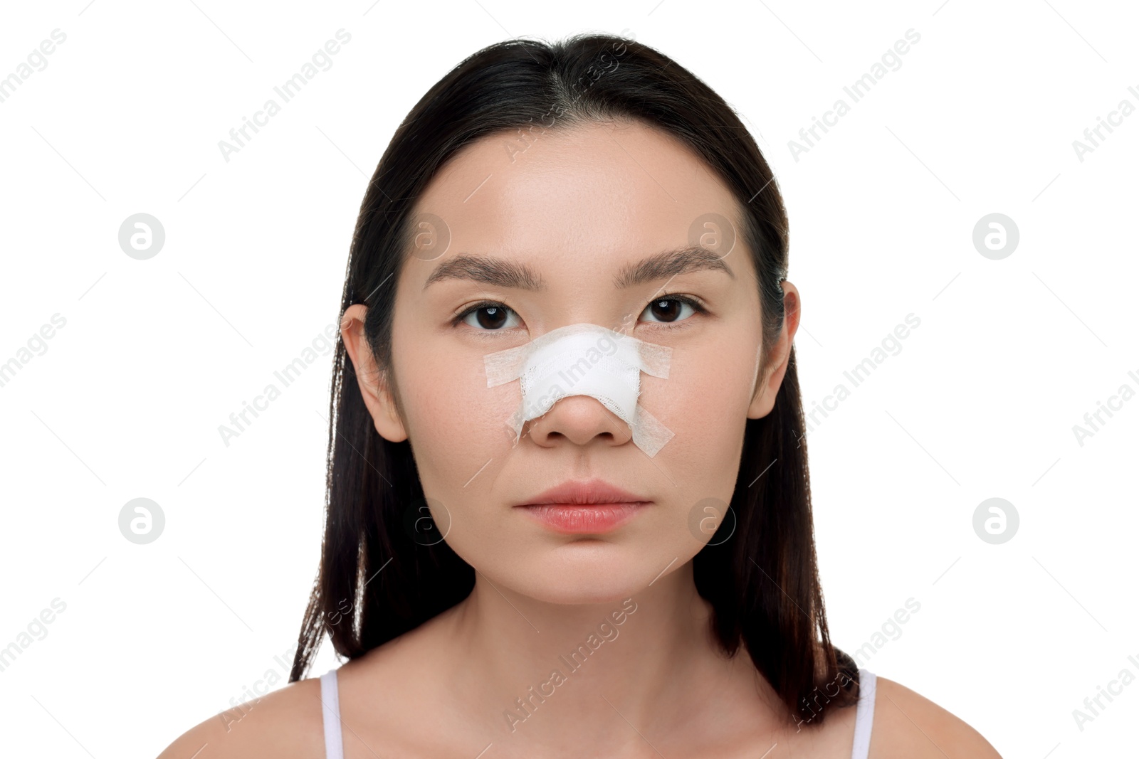 Photo of Woman with medical bandage on her nose after plastic surgery operation against white background