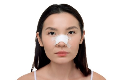 Photo of Woman with medical bandage on her nose after plastic surgery operation against white background