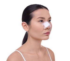 Woman with medical bandage on her nose after plastic surgery operation against white background